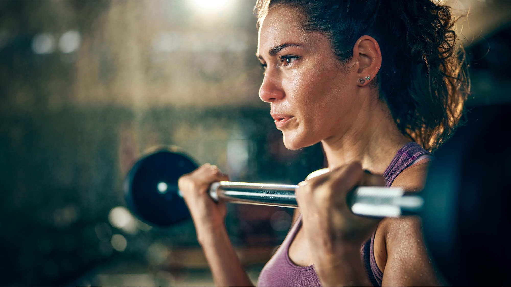 woman-bicep-curl-barbell-closeup-hero-16-9-2560x1440px