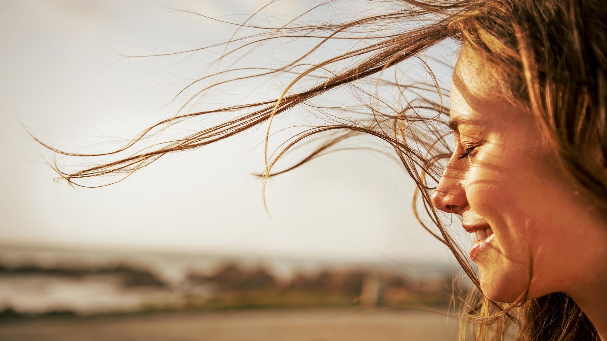 woman-wind-smiling-wellbeing-16-9-hero-2560x1440px