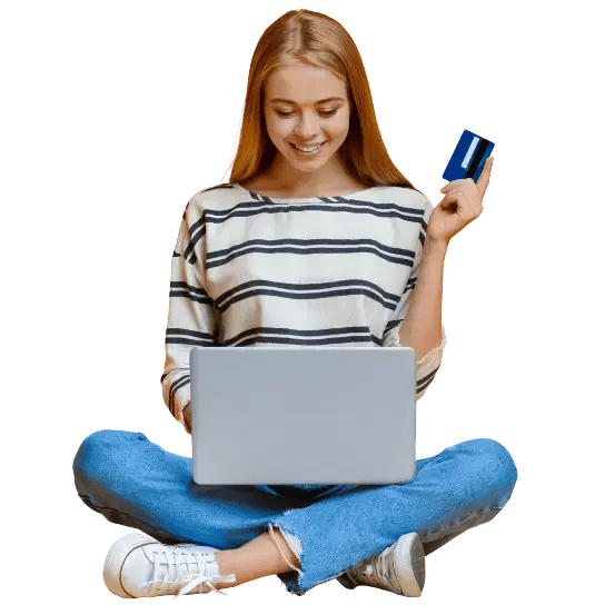 A woman sitting on the floor with a laptop and credit card, exploring employee benefit schemes online.