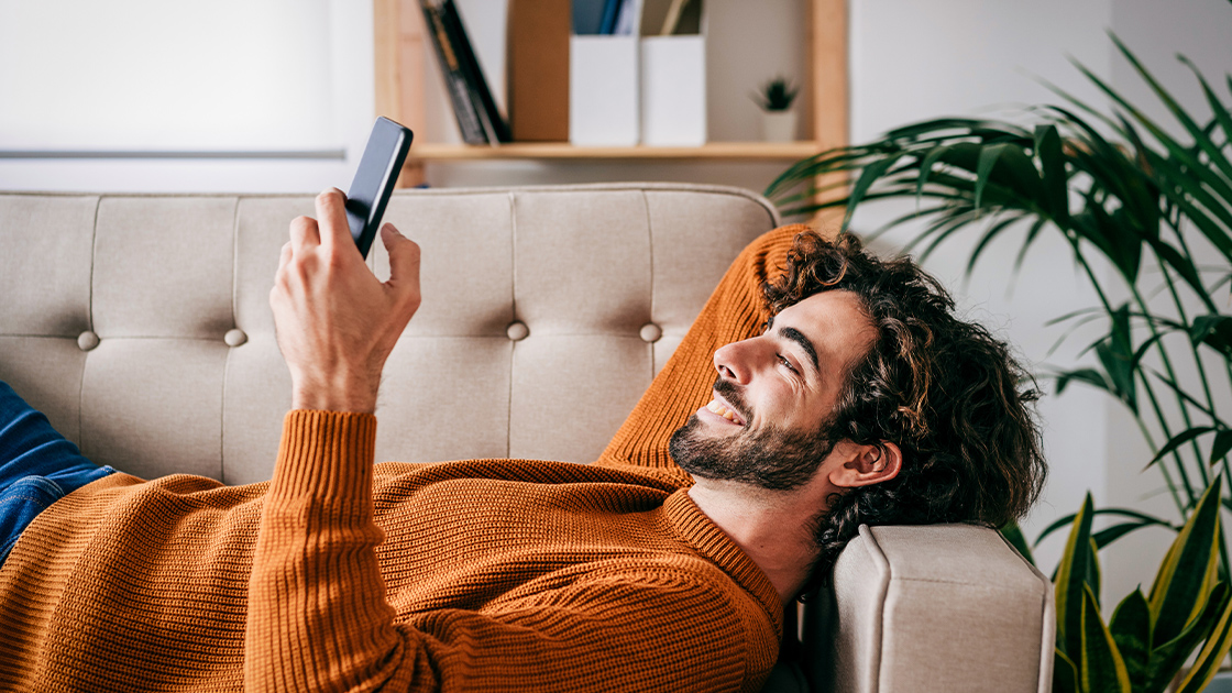 man-couch-phone-happy-16-9-1120x630px