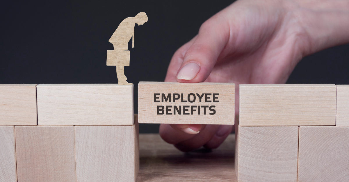 A hand places a wooden block labeled “Employee Benefits” to bridge a gap between wooden platforms.